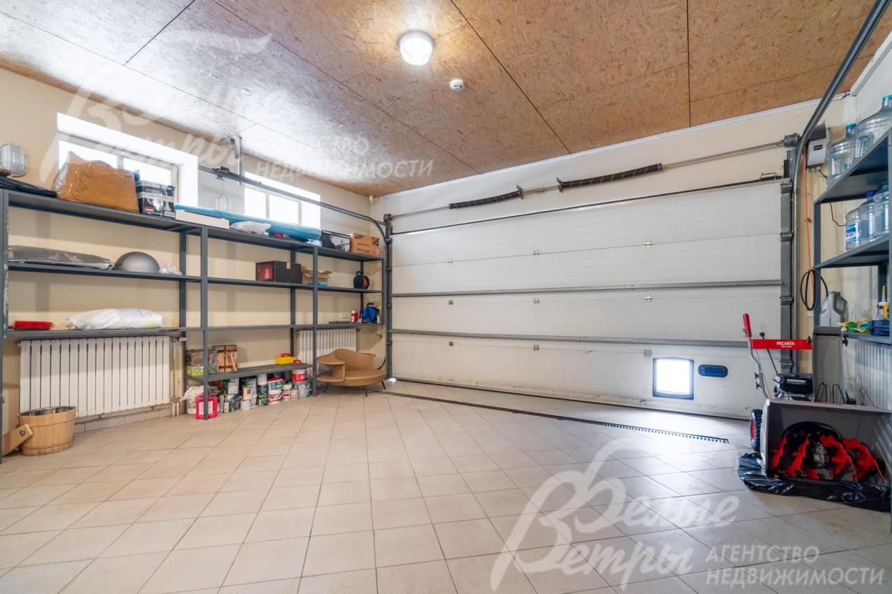 На первом этаже находится гараж, рассчитанный на два автомобиля и дополненный стеллажами