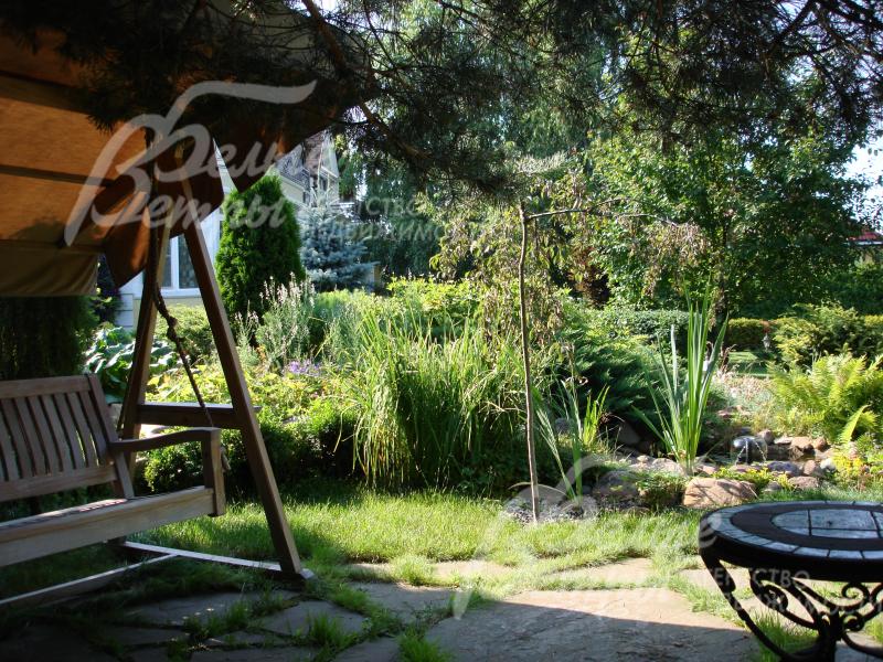 Под тенистыми ветвями кедра обустроена зона барбекю