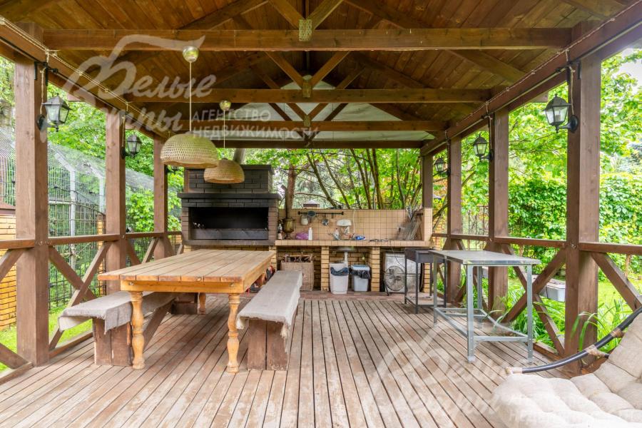 В беседке установлен мангал, деревянная мебель