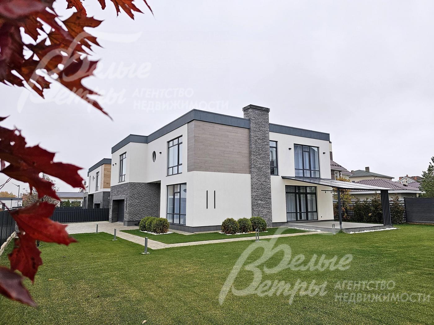 Дом стоит на просторном зелёном участке с высаженным газоном и вымощенными дорожками