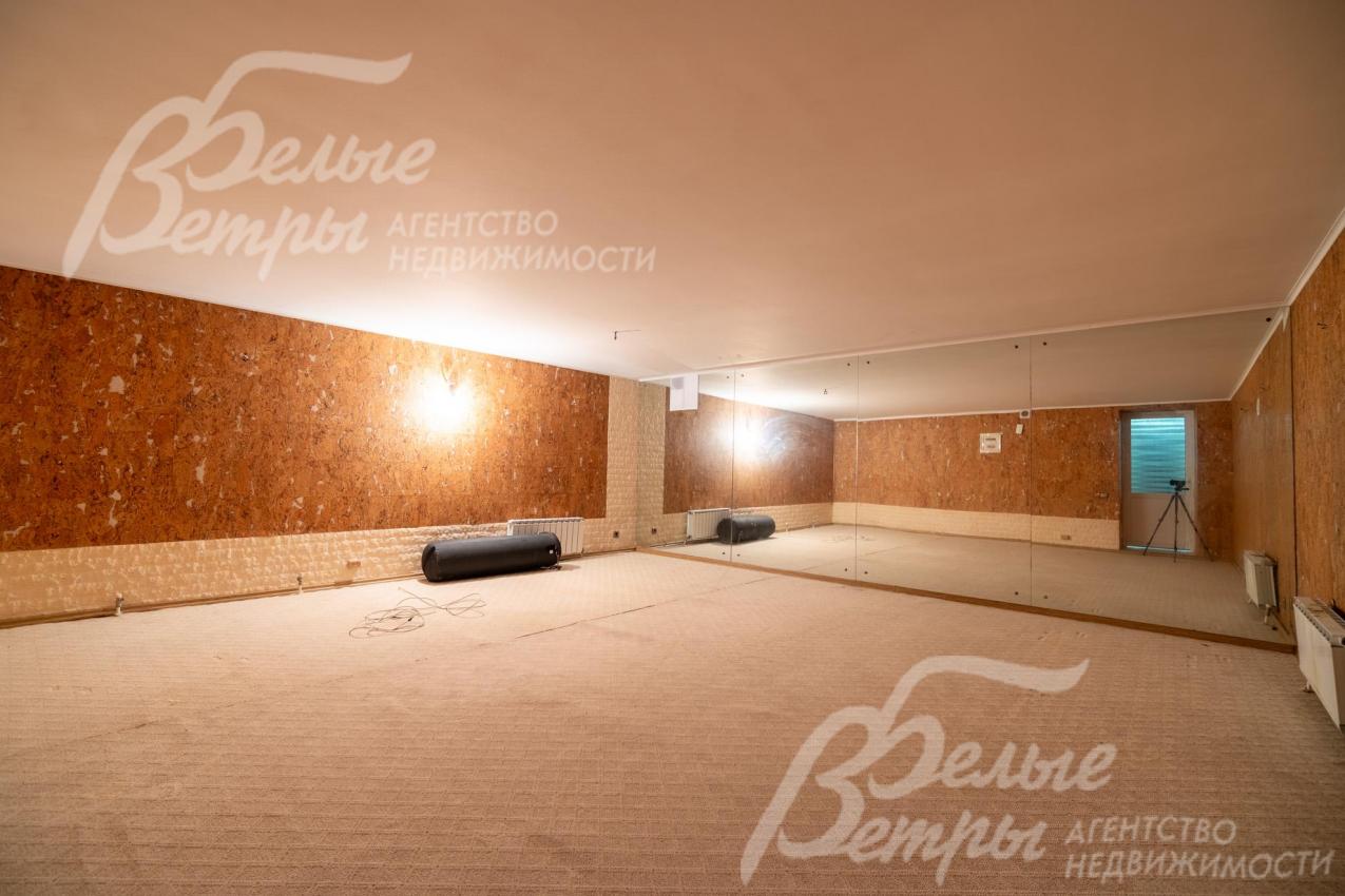 Пространство спортзала на цокольном этаже, одна из стен - зеркальная