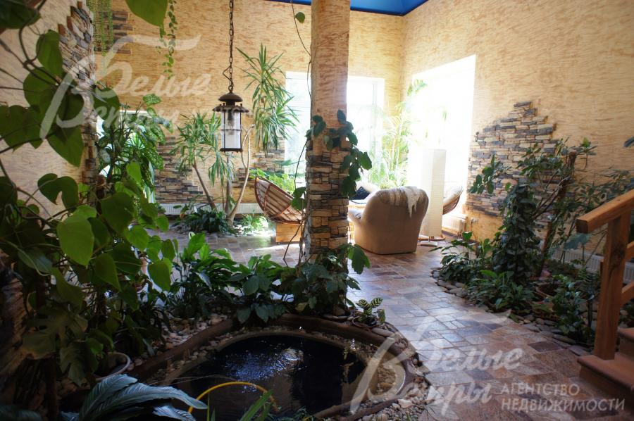  Зимний сад со множеством растений и декоративным прудиком