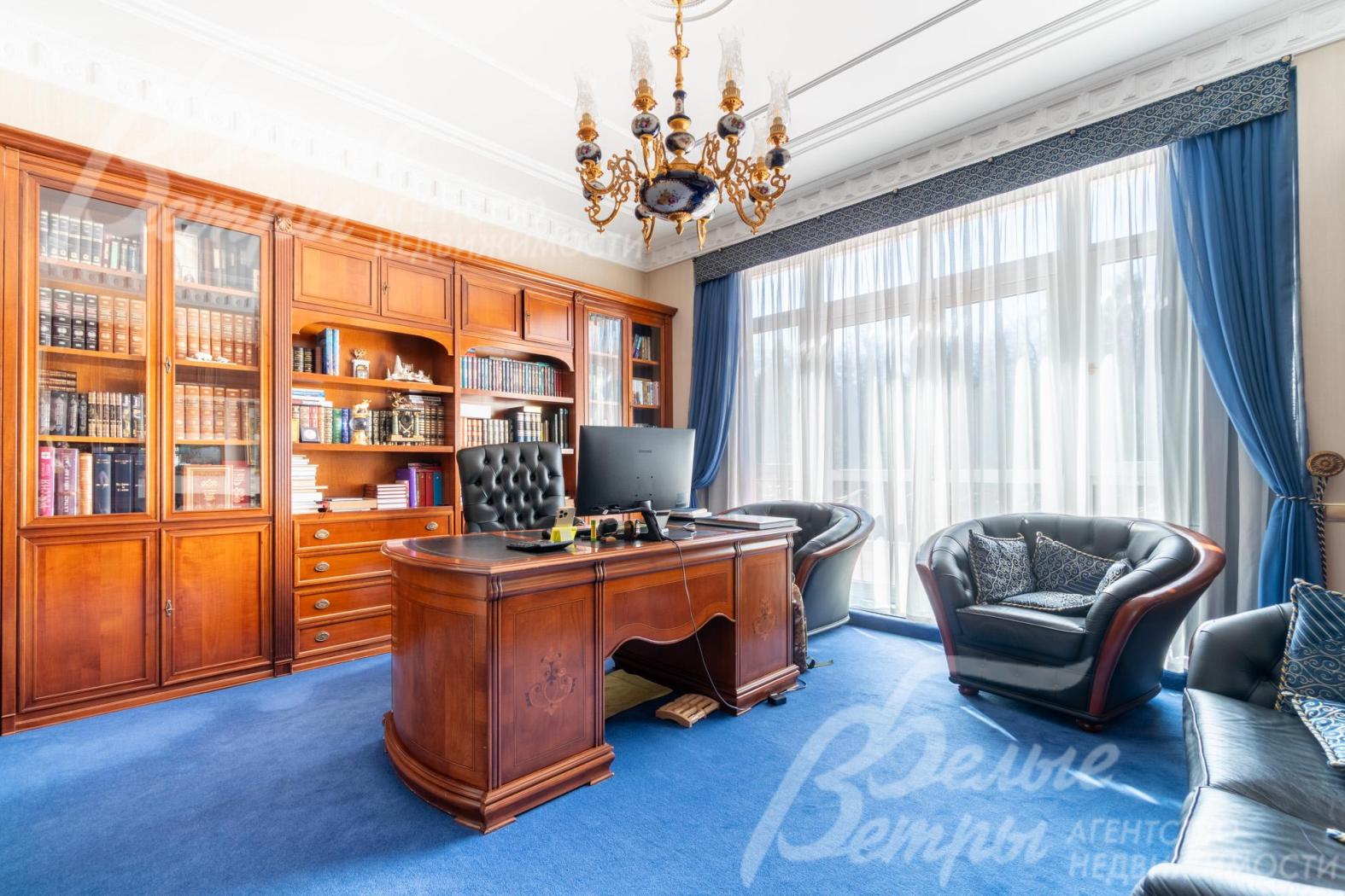 В кабинете: большой письменный стол, шкафы‑витрины, стеллажи и кожаный диван с двумя креслами