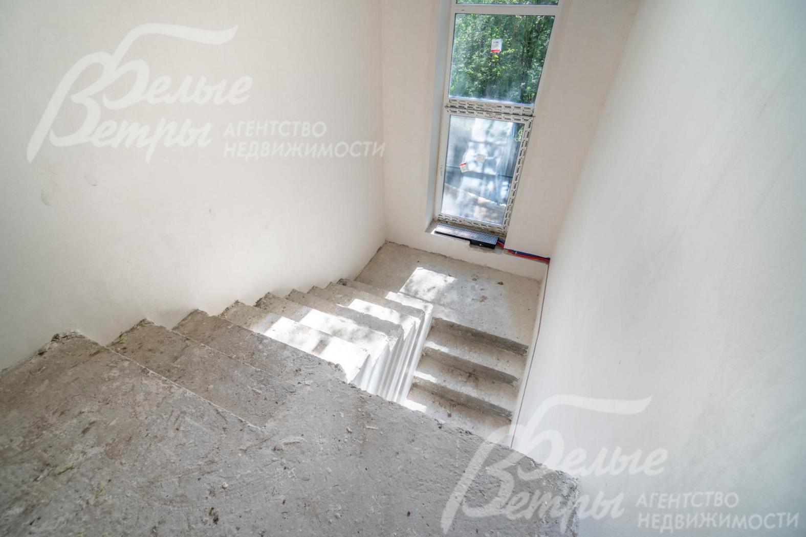 На лестничном пролёте - высокое окно, через которое лестница и холл 2-го этажа наполняются естественным светом