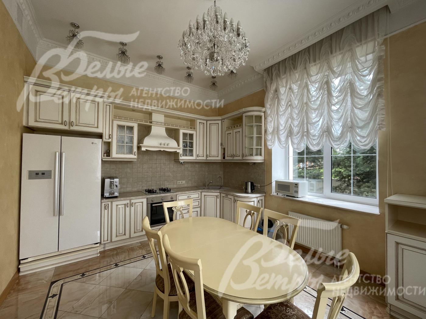 Кухонный гарнитур с фасадами из массива дерева с резными элементами, фурнитура - фарфор с латунью, столешница из камня