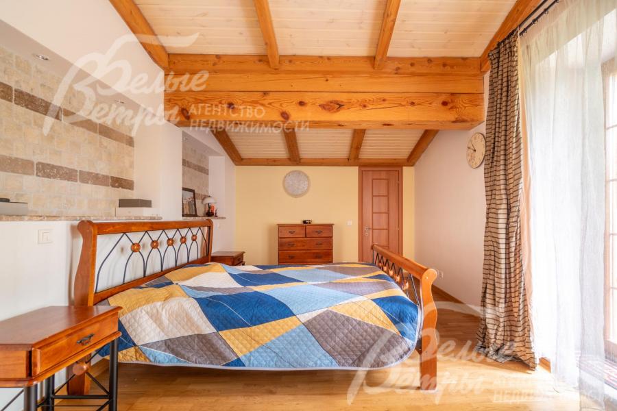 Одна из спален на втором этаже с выходом на балкон