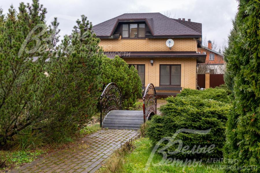 Вдоль дорожки, ведущей к гостевому дому, высажены густые кустарники и хвойные деревья