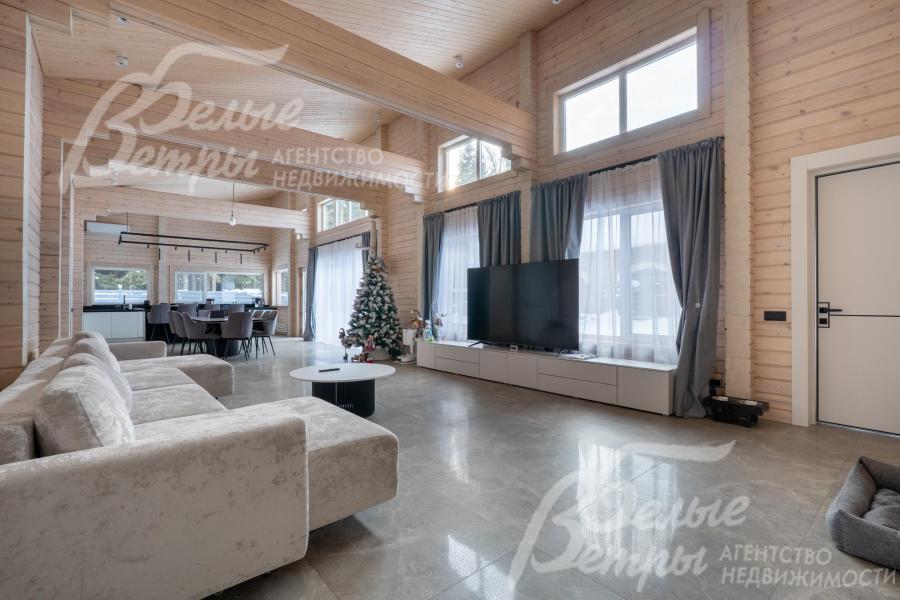 Гостиная - двухсветная, в ней установлен уютный диван и телевизор с акустической системой