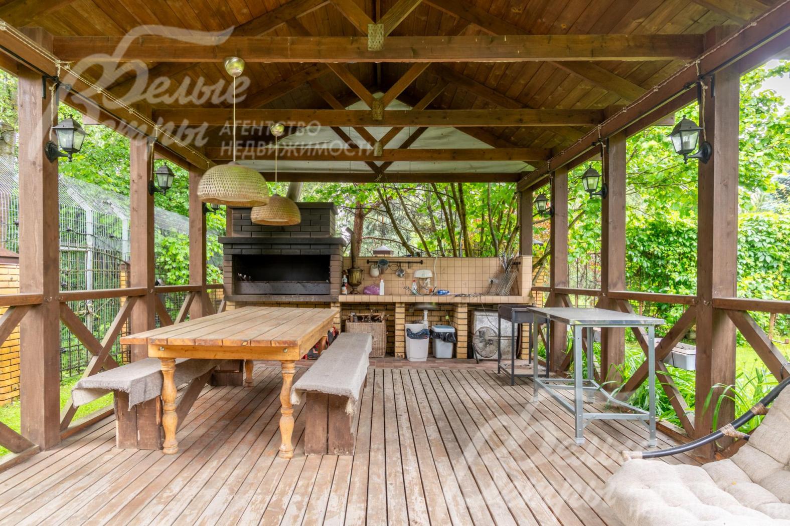 В беседке установлен мангал, деревянная мебель