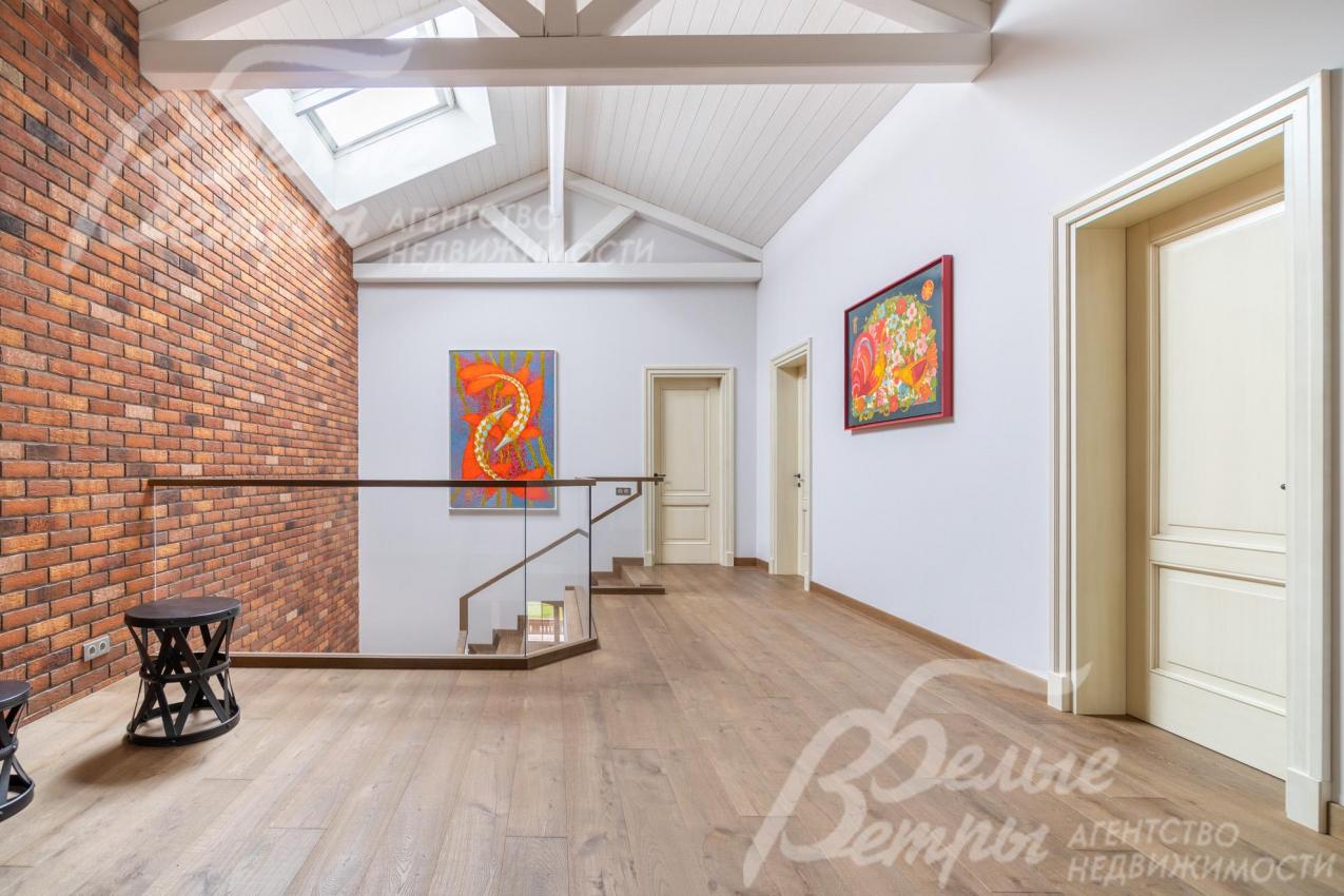 Холл второго этажа с акцентной стеной, оформленной в стиле лофт, массивными балками  и мансардными окнами Velux. Двери - из массива каштана с сатиновым покрытием