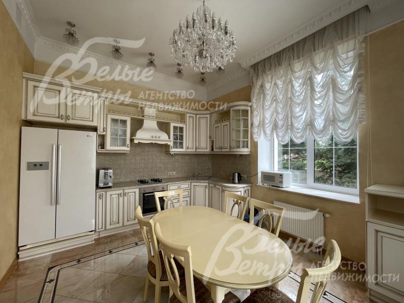 Кухонный гарнитур с фасадами из массива дерева с резными элементами, фурнитура - фарфор с латунью, столешница из камня